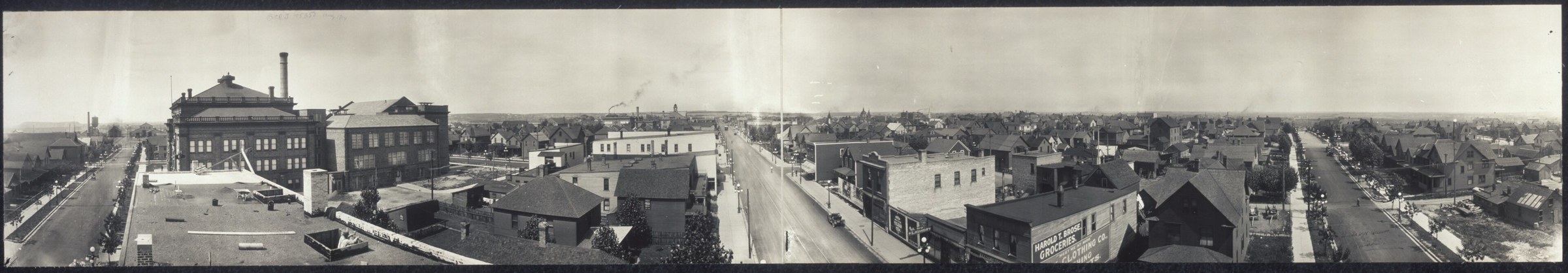A wide panorama over the roofs of a small town of brick blocks and frame houses, with long straight streets