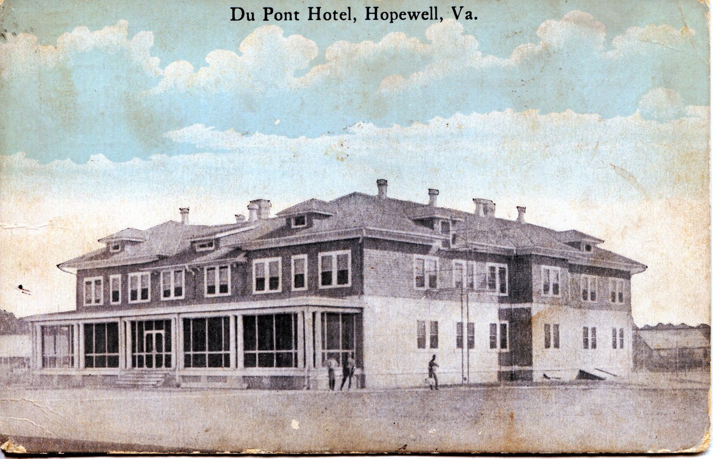 A large two-storey hotel with long verandas on a bare street at Hopewell