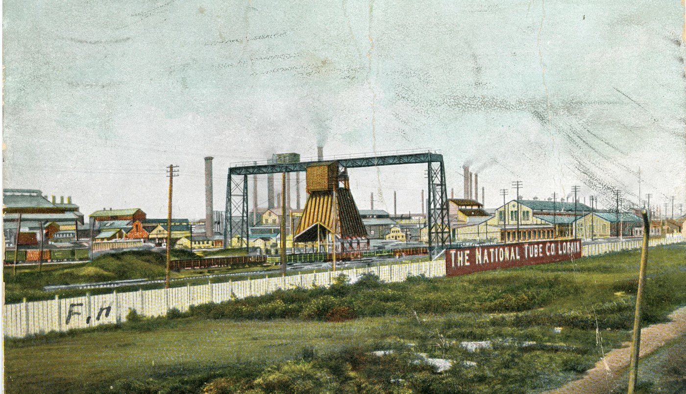 Colour postcard of the National Tube Company works at Lorain, with the company's name on a long fence, 1907