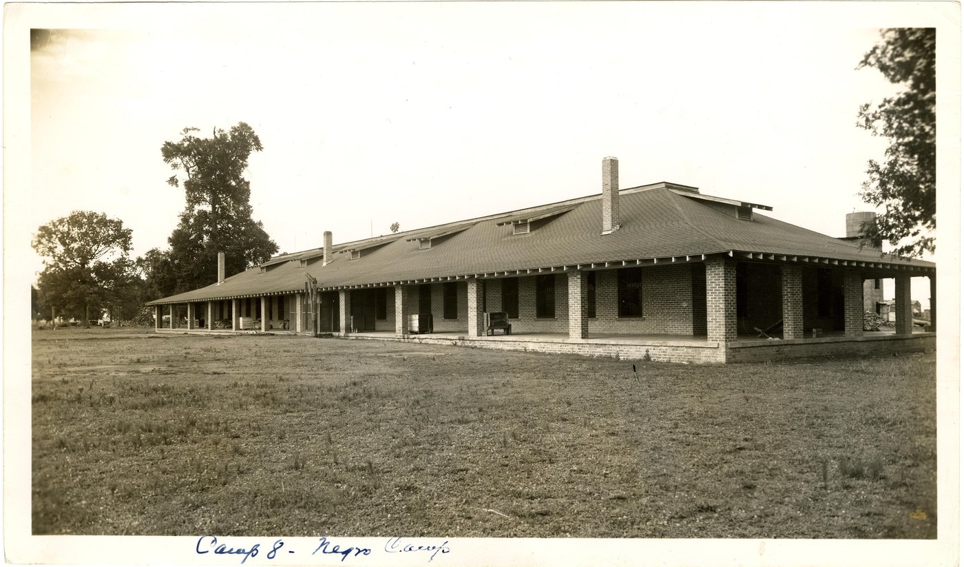 A long single-storey brick camp building at Parchman, with a handwritten caption reading Camp 8, Negro Camp